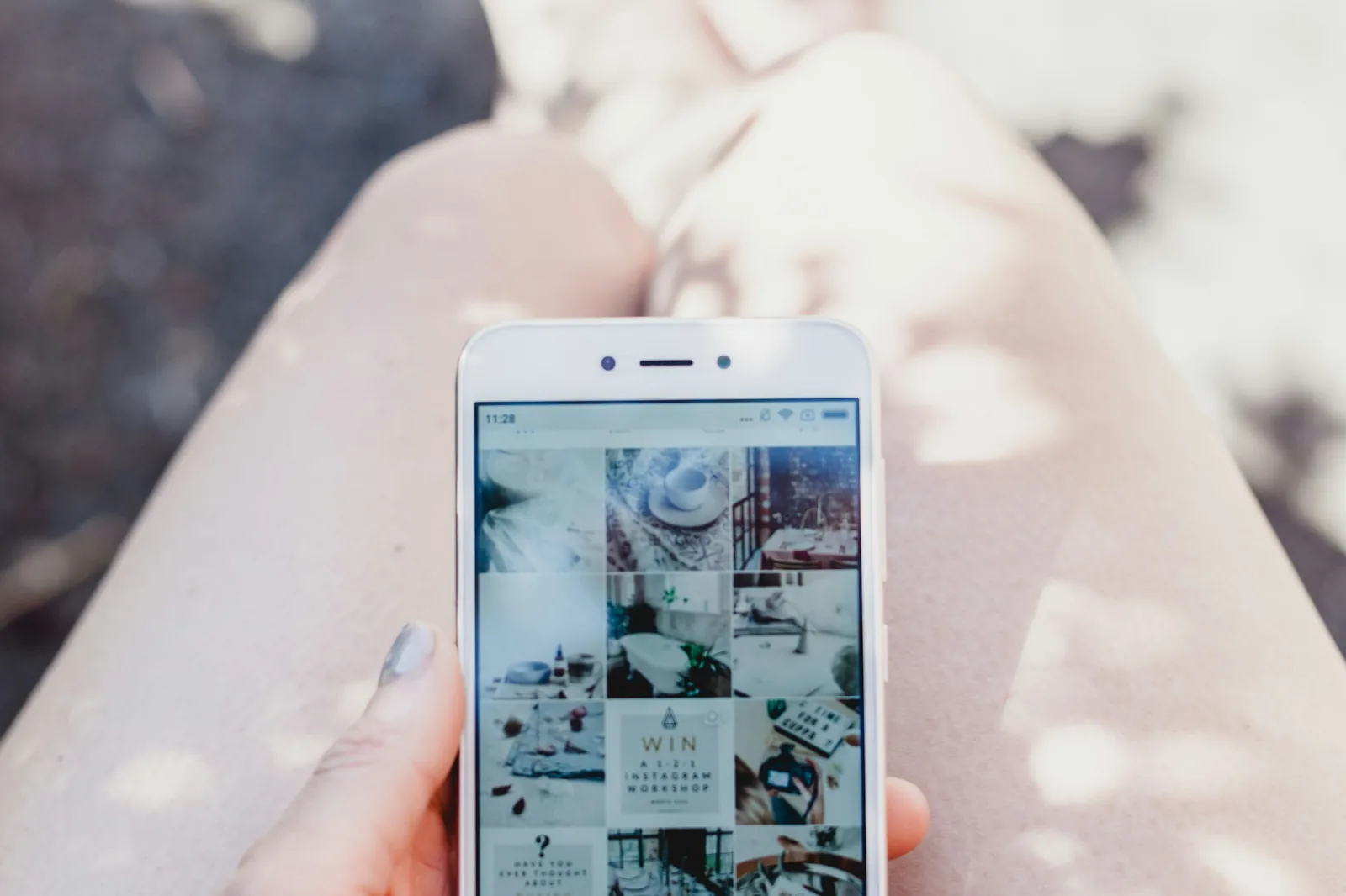 Instagramのフィードを表示したスマートフォンを手に持っているところ