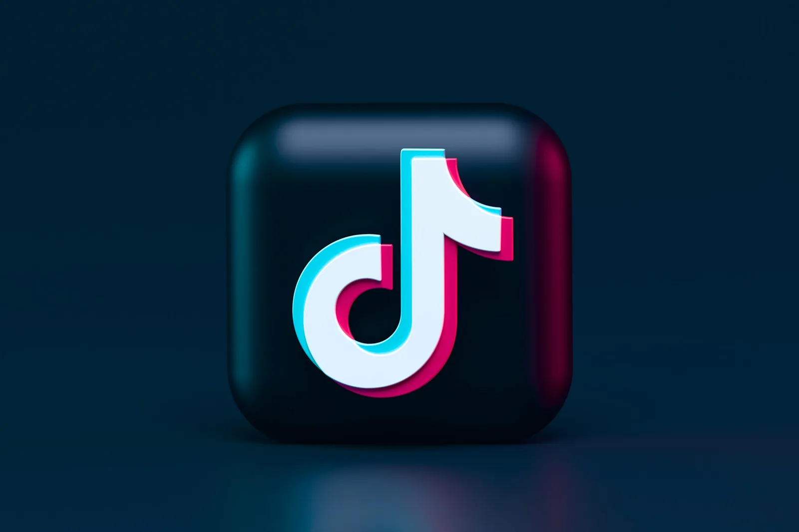 暗い背景に浮かぶ立体的なTikTokのアプリアイコン